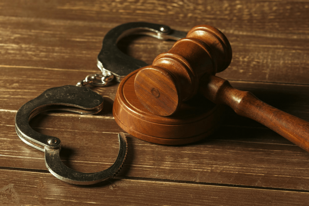 A gavel and handcuffs on a wooden surface