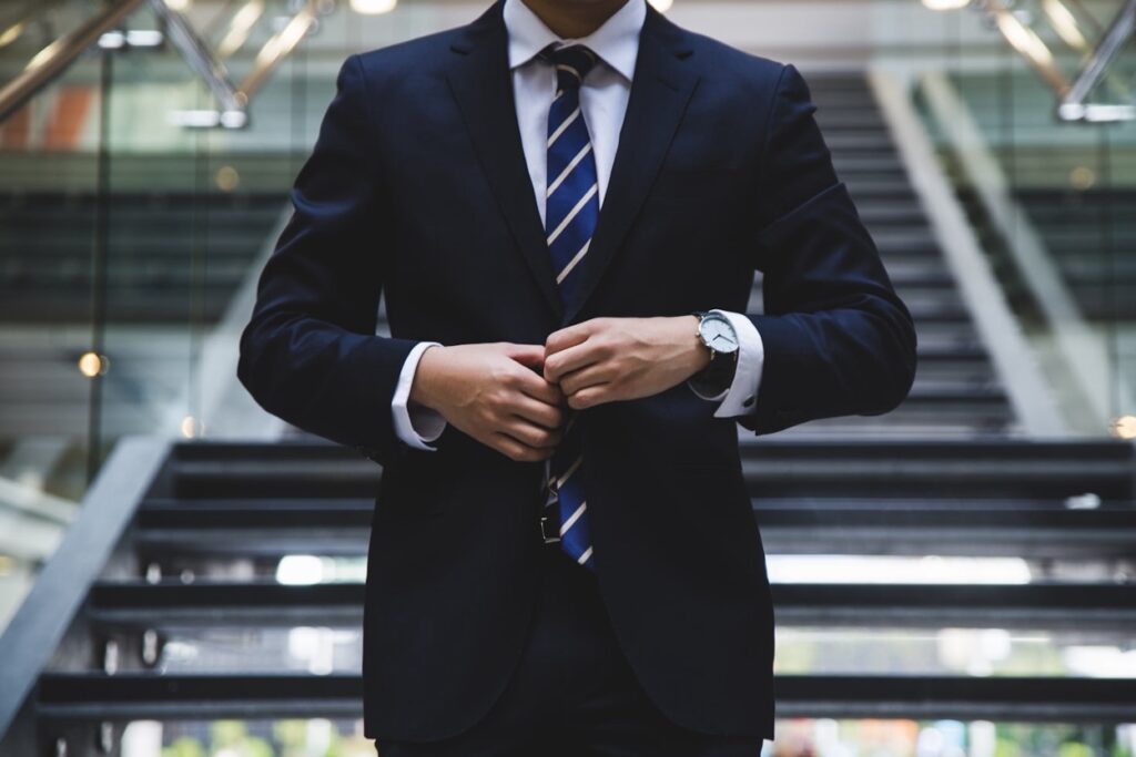 A lawyer buttoning his suit as he goes down a staircase