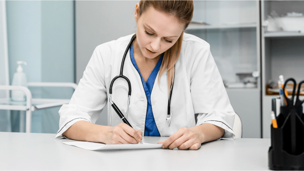 A nurse filling out paperwork at a desk in a medical facility