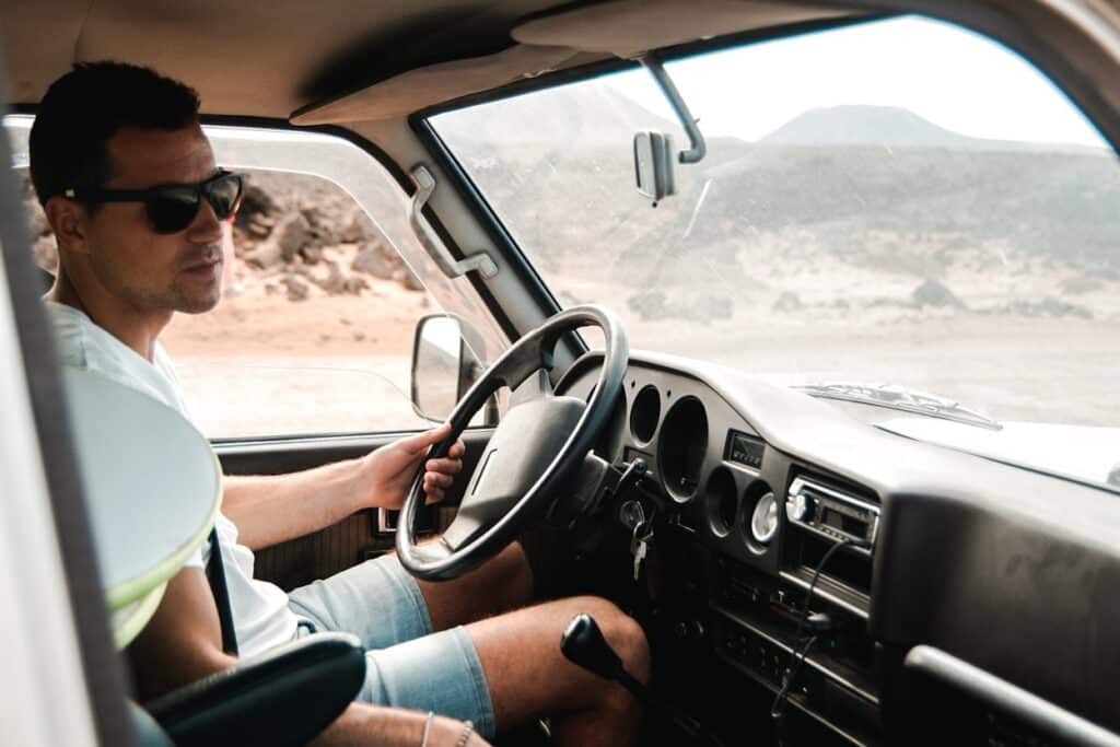 A truck driver inside his truck in casual wear 