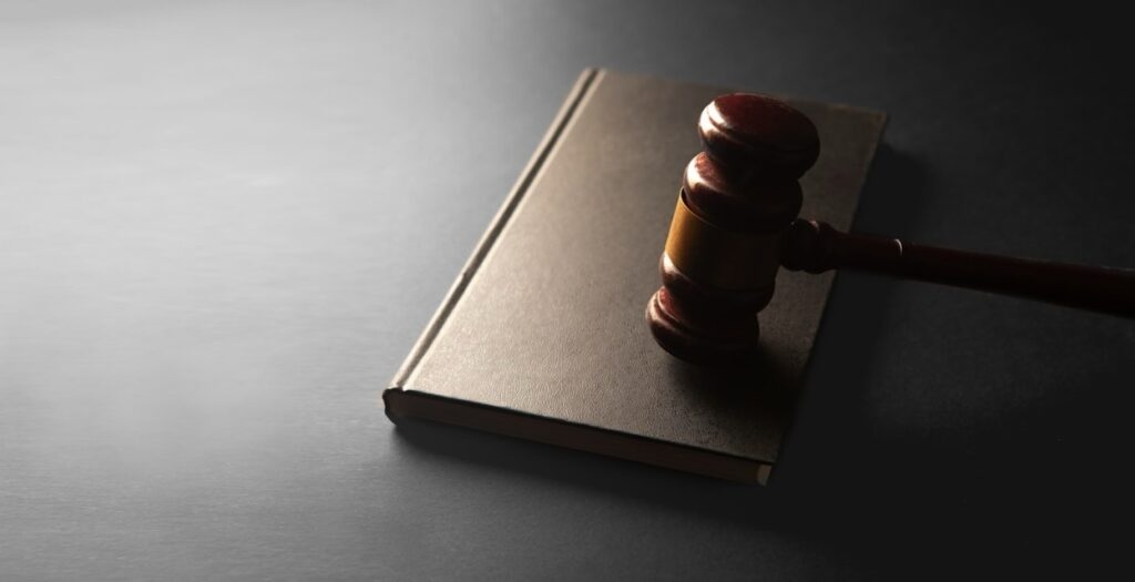 A wooden gavel rests on a closed book