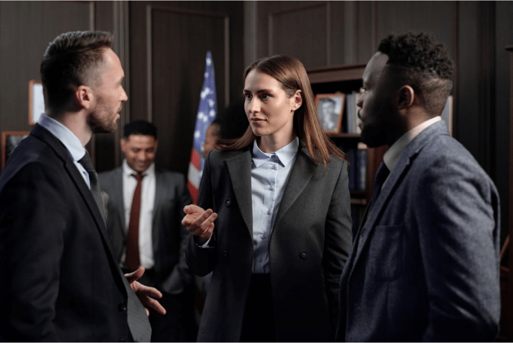 Attorneys discussing a case in a law office with an American flag in the background