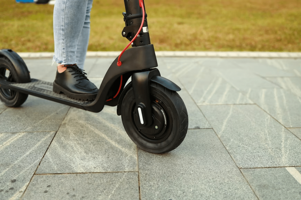 Close-up of a person standing on an electric scooter