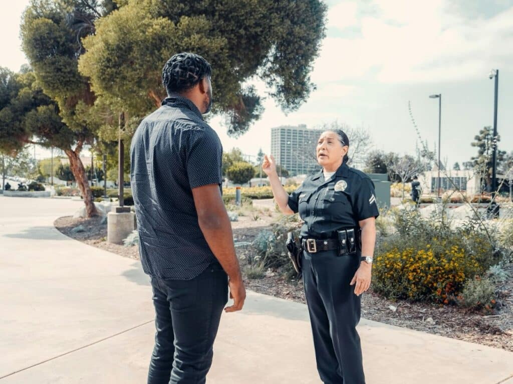 A female police officer speaks with a civilian man