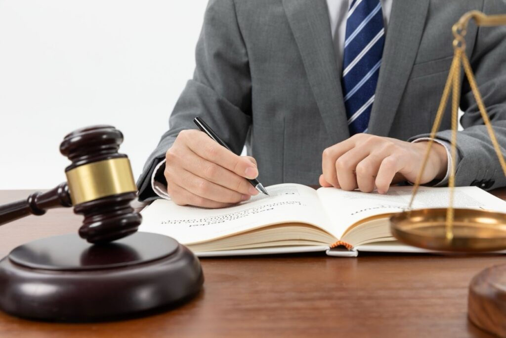 A legal professional in a gray suit writing notes