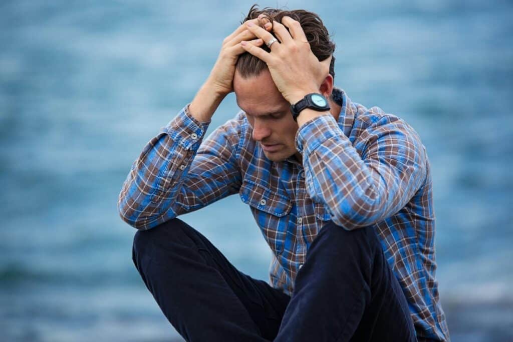 A man holding his head in his hands in a gesture of distress or overwhelm