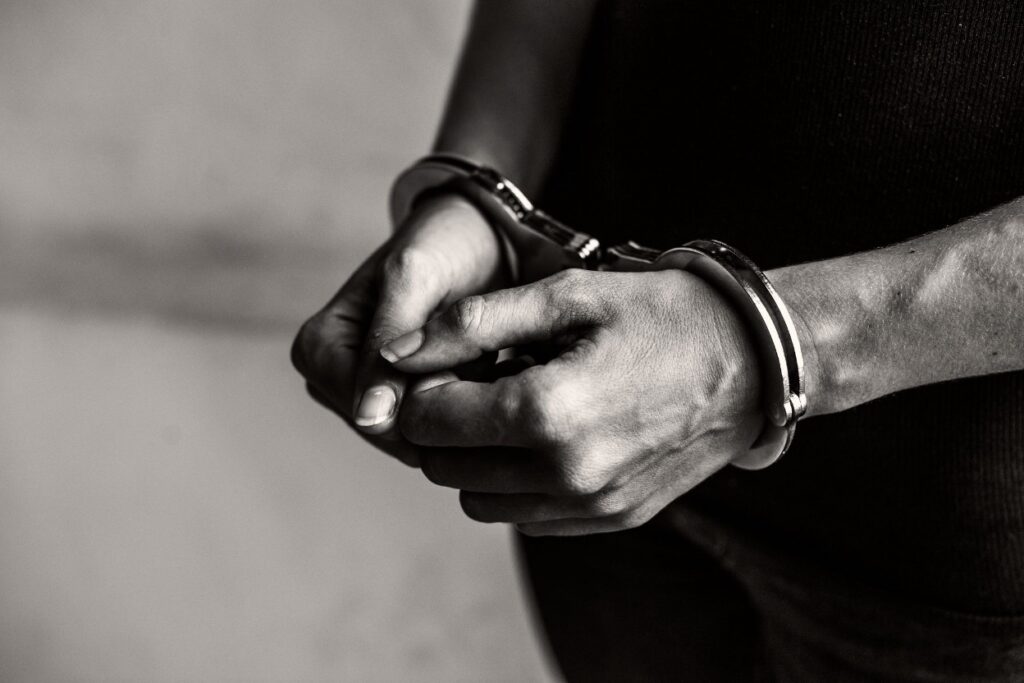 Close-up black and white photo of a person's hands in handcuffs