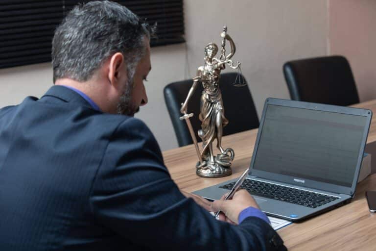 Frisco DWI lawyer in a suit reviewing case files on a laptop in a conference room.