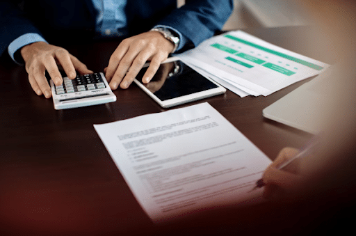 Person in a suit calculating DWI lawyer fees beside legal documents and a tablet