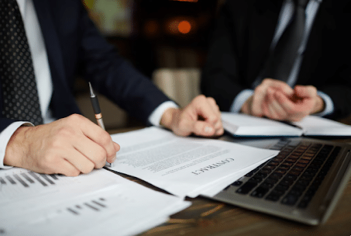 Two professionals in suits review a DWI defense contract on a desk in Killeen, TX