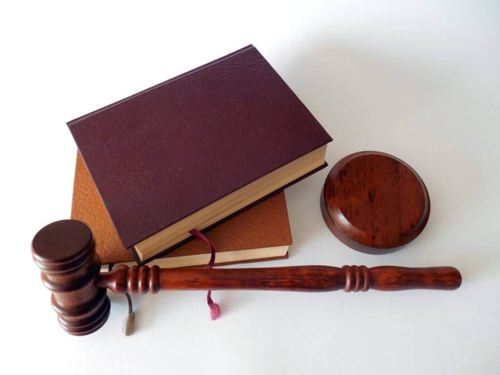 Wooden judge's gavel beside two leather-bound law books used in DWI defense cases.